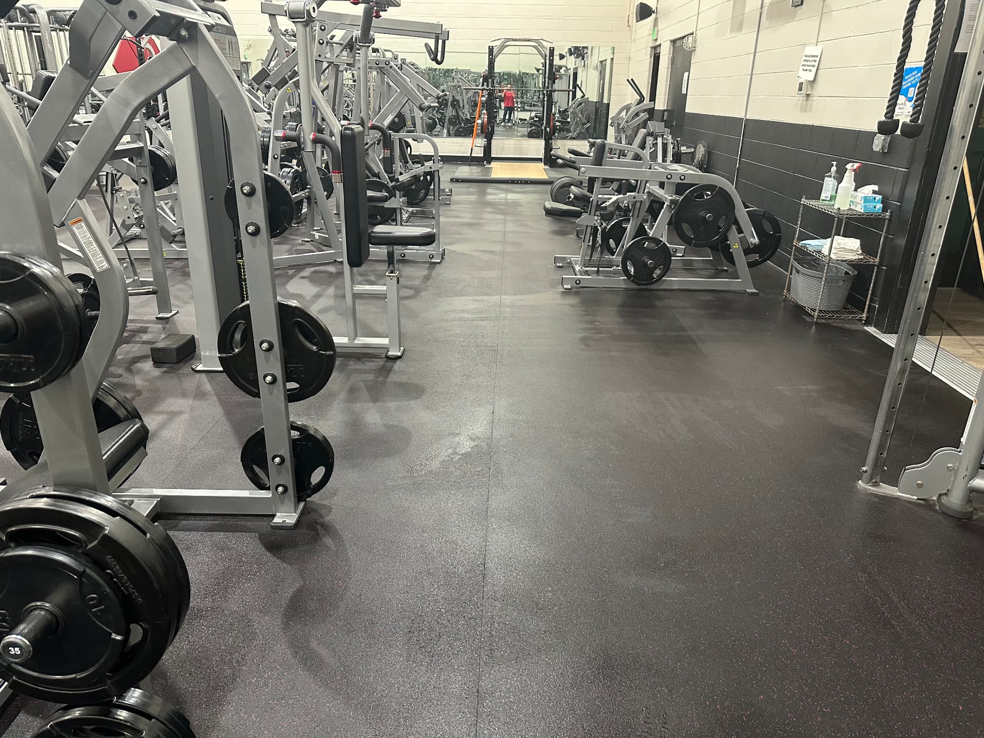 Gym weight room with rubber flooring scrubbed and strength equipment sanitized by Hello Clean & Company
